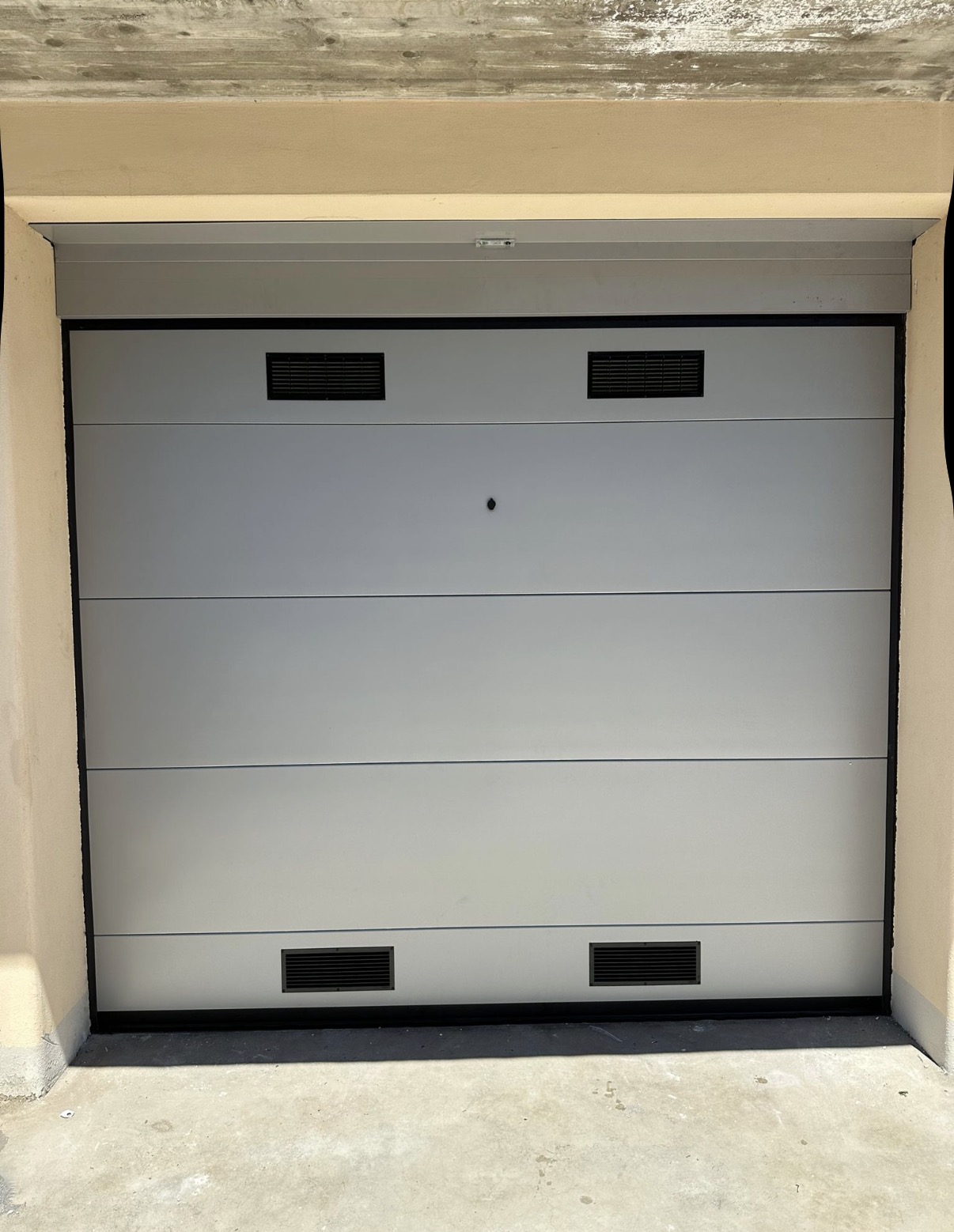 porta sezionale a <p>porta sezionale oltre luce, con griglie di areazione, sblocco esterno, lampeggiante e pannello intero. RAL 9006</p>