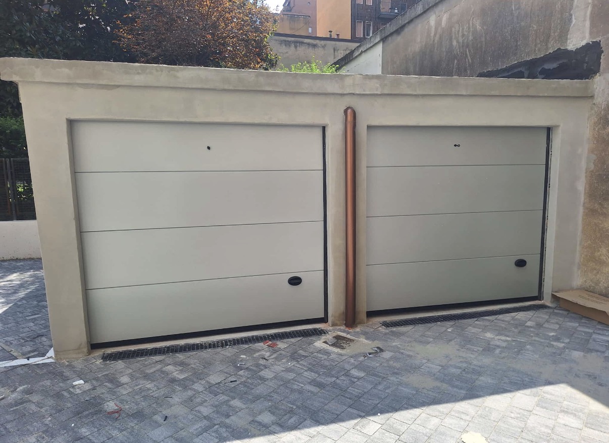 porta sezionale a <p>porta sezionale oltre luce, con sblocco esterno, maniglia di sollevamento e pannello intero. RAL a campione</p>
