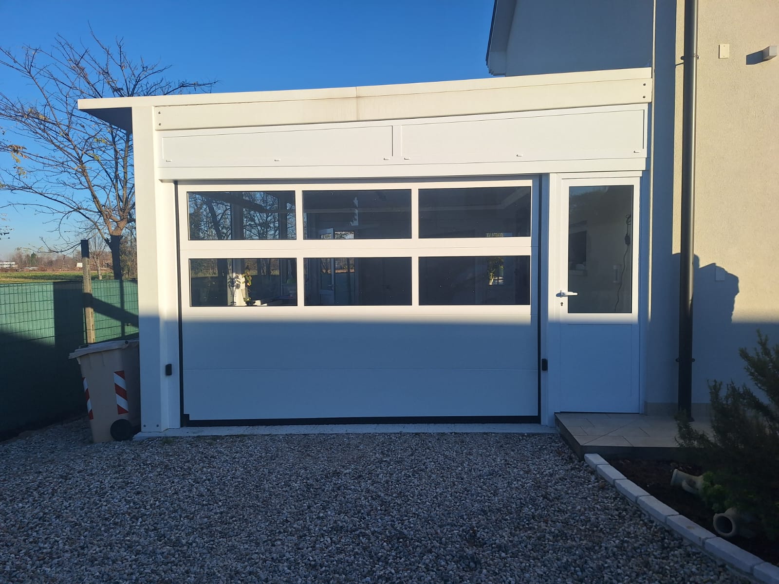 porta sezionale a <p>porta sezionale oltre luce, con fotocellule e pannello con oblò. RAL 9010</p>