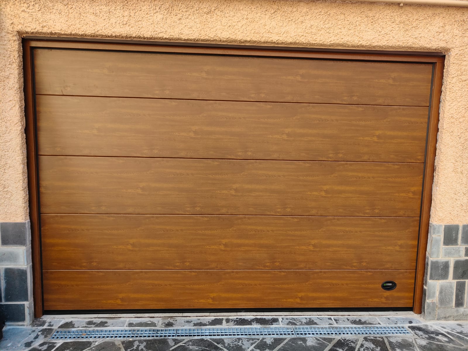 porta sezionale a <p>porta sezionale oltre luce, con maniglia di sollevamento e pannello intero. Colore effetto legno chiaro</p>