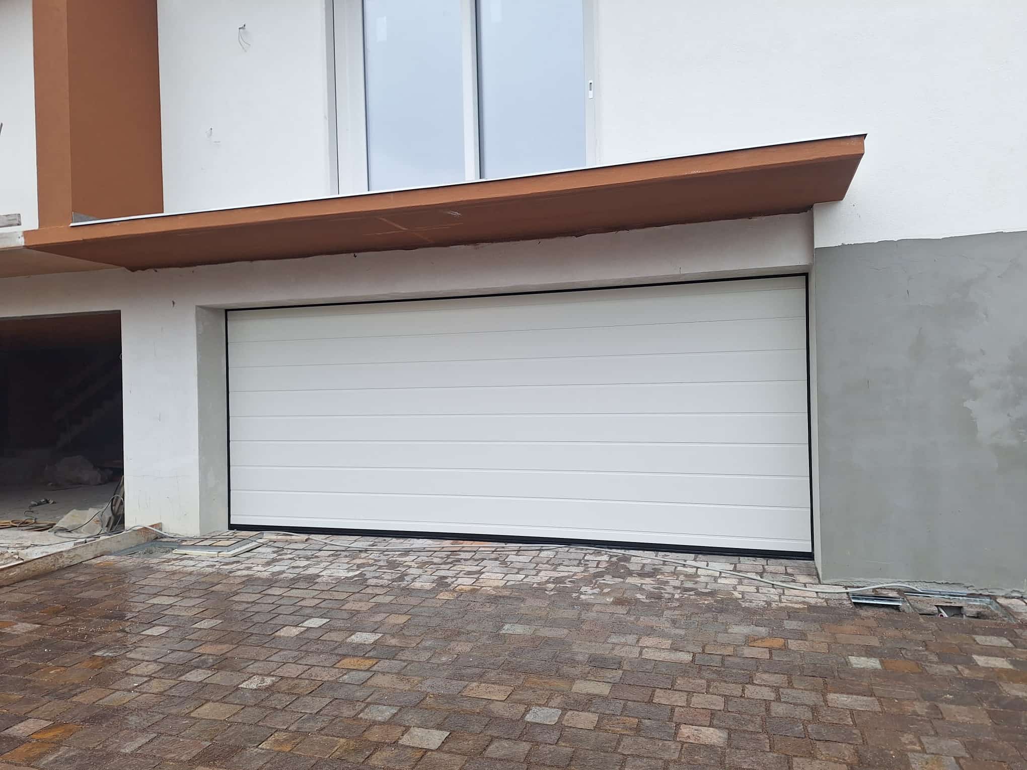 porta sezionale a <p>porta sezionale oltre luce, con pannello con doga da 25cm. RAL 9010</p>