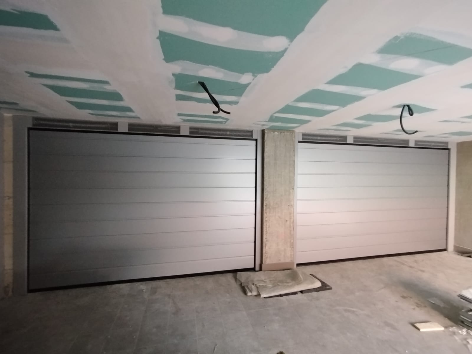 porta sezionale a <p>porta sezionale in luce, con veletta areata e pannello con doga da 25cm. RAL 9006</p>