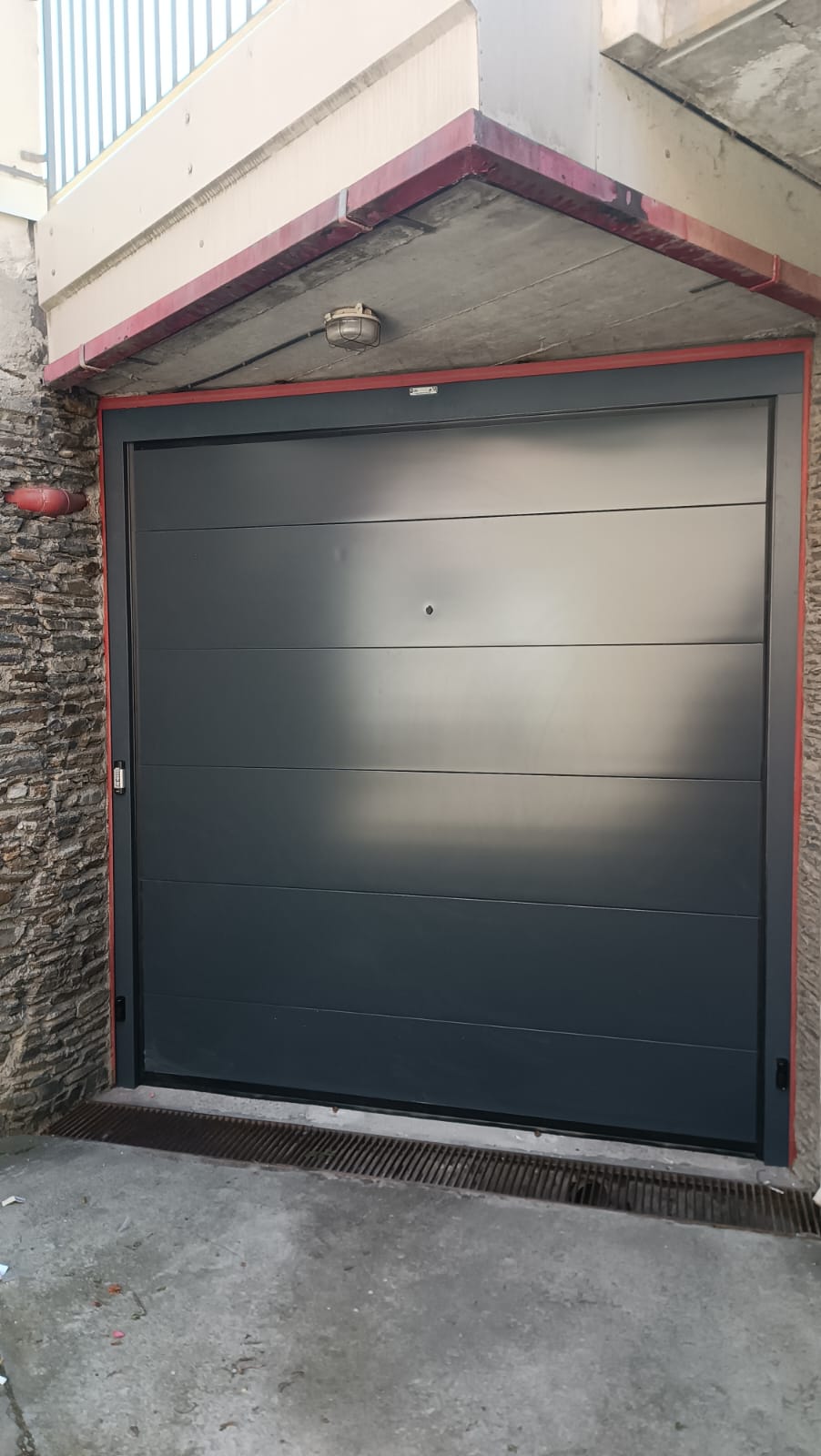 porta sezionale a <p>porta sezionale in luce, con lampeggiante, sblocco esterno, fotocellule, telecodi e pannello intero. RAL 7016</p>