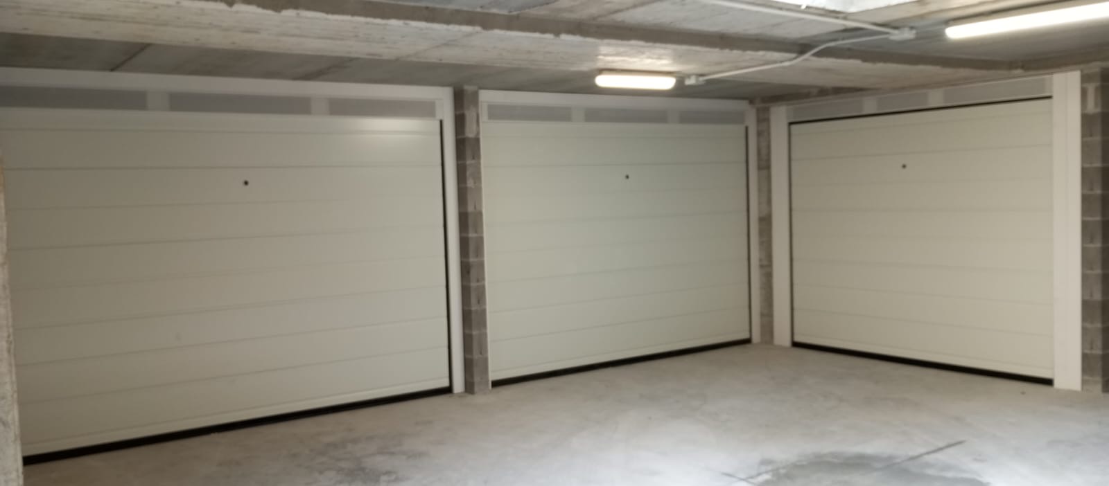 Porta sezionale a <p>Porta sezionale in luce, con veletta areata, sblocco esterno e pannello con doga da 25cm. RAL 9010</p>