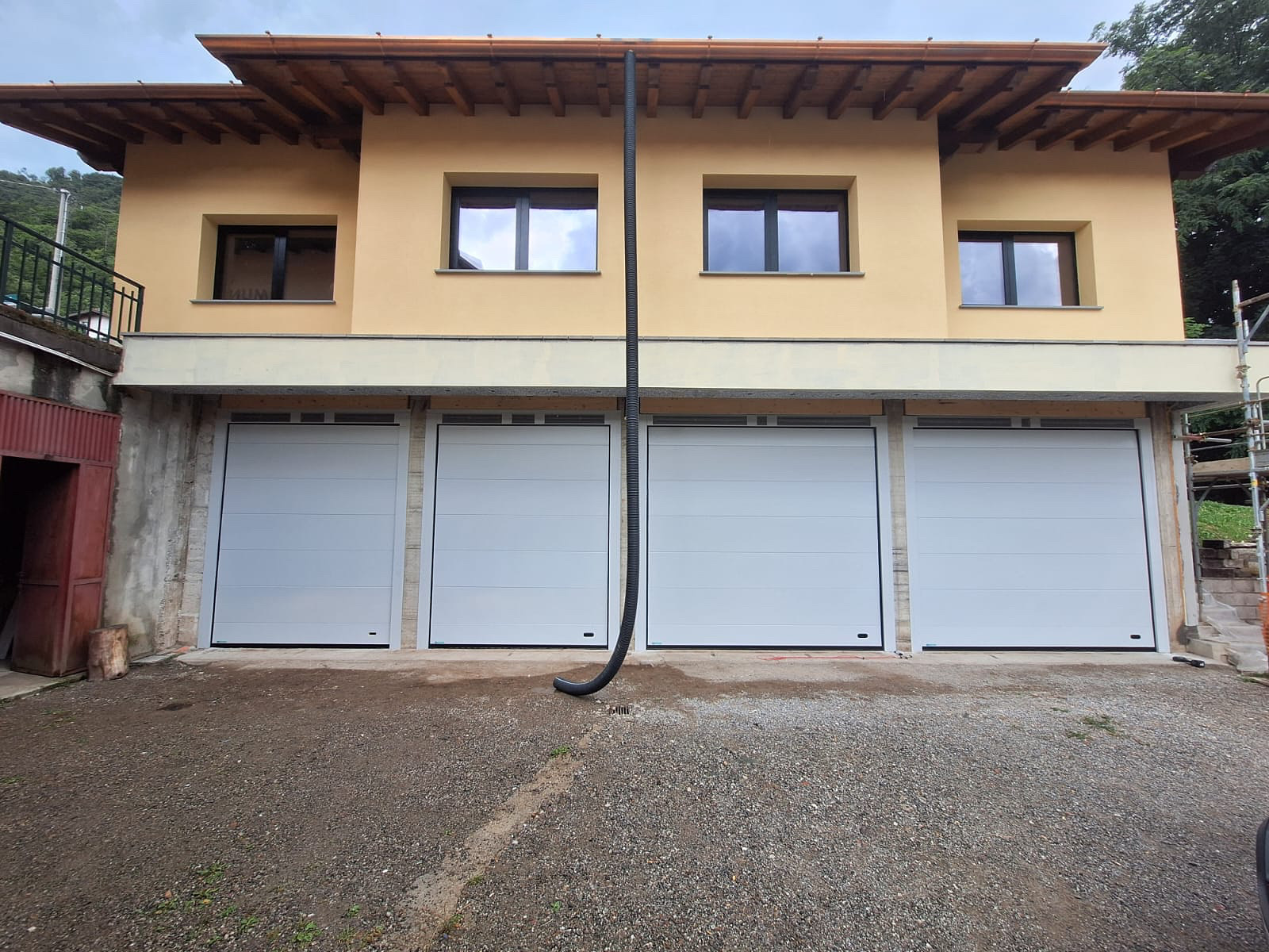 Porta sezionale a <p>Porta sezionale in luce, con veletta areata, maniglia di sollevamento e pannello intero. RAL 7035</p>