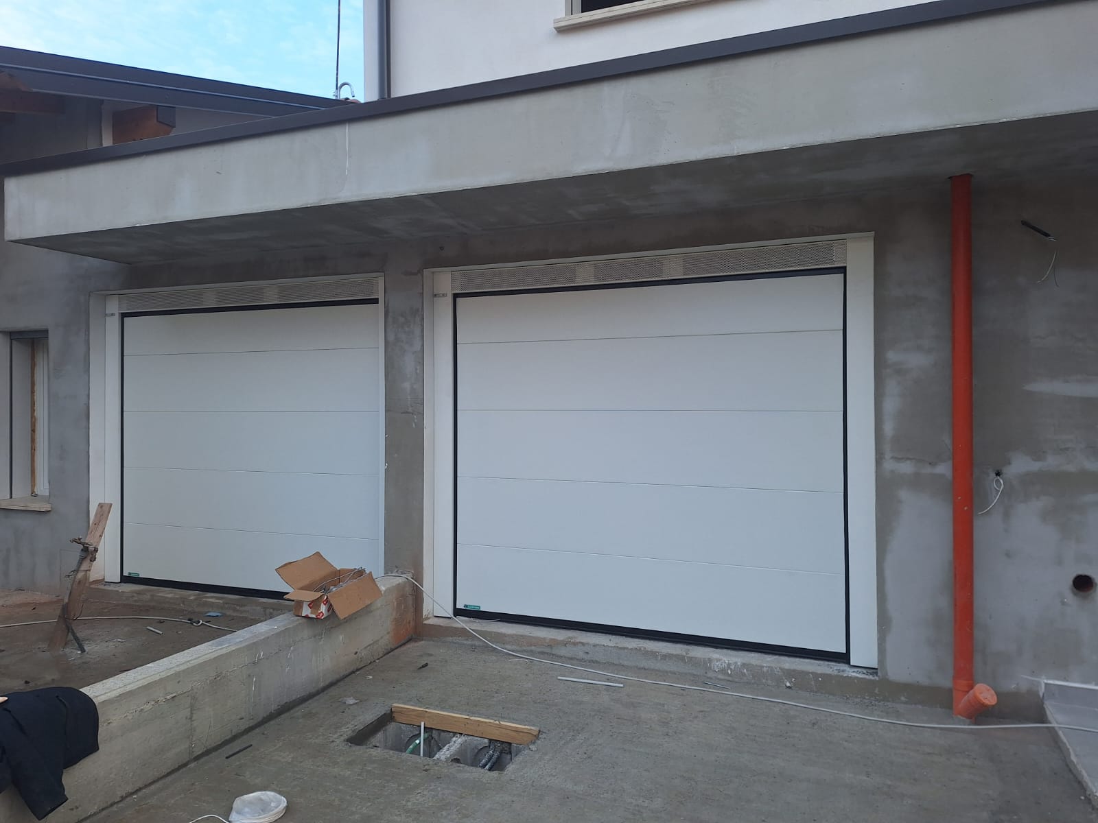 porta sezionale a <p>porta sezionale in luce, con veletta areata, lampeggiante e pannello intero. RAL 9010</p>