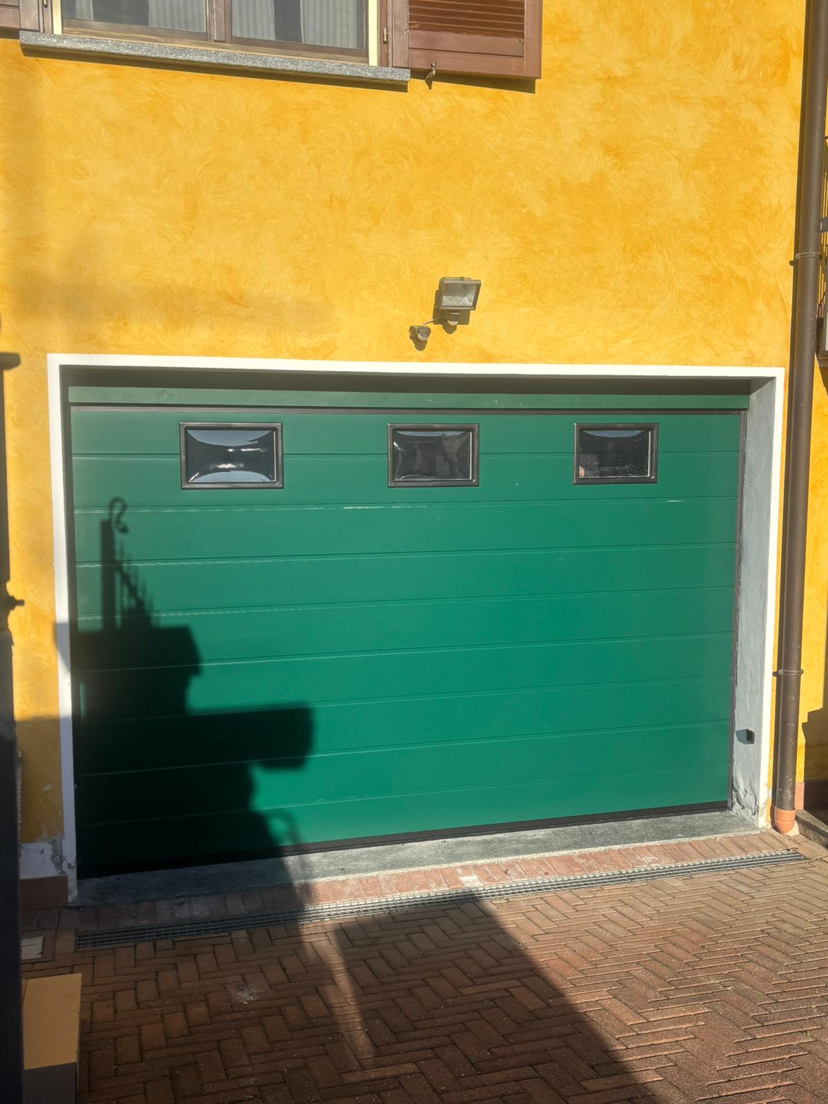 porta sezionale a <p>porta sezionale oltre luce, con oblò e pannello con doga da 25cm. RAL 6005</p>