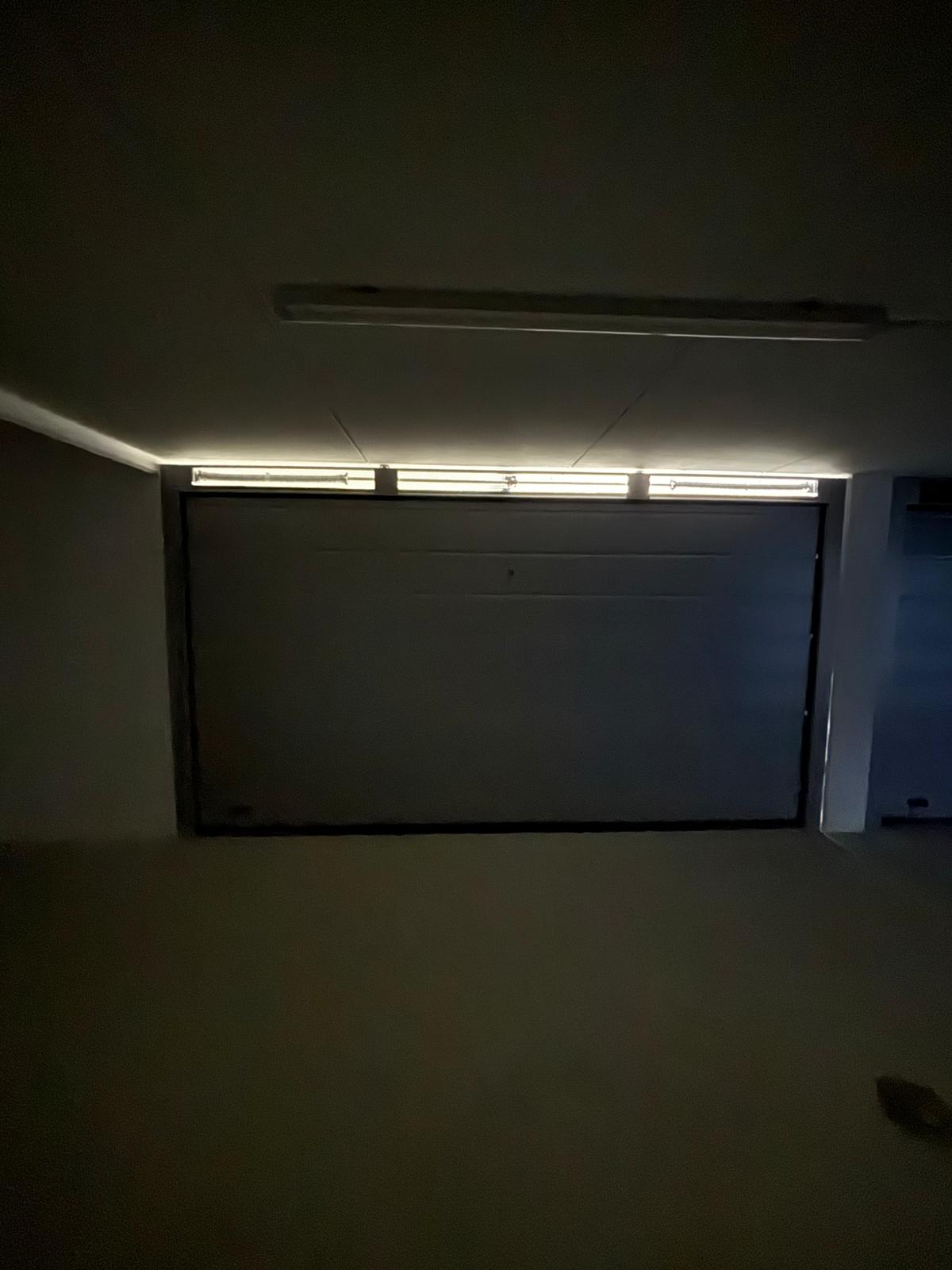 portone sezionale a <p>porta sezionale in luce, con veletta areata, griglie di areazione, maniglia di sollevamento, sblocco esterno e pannello con doga da 24cm. RAL 9006</p>