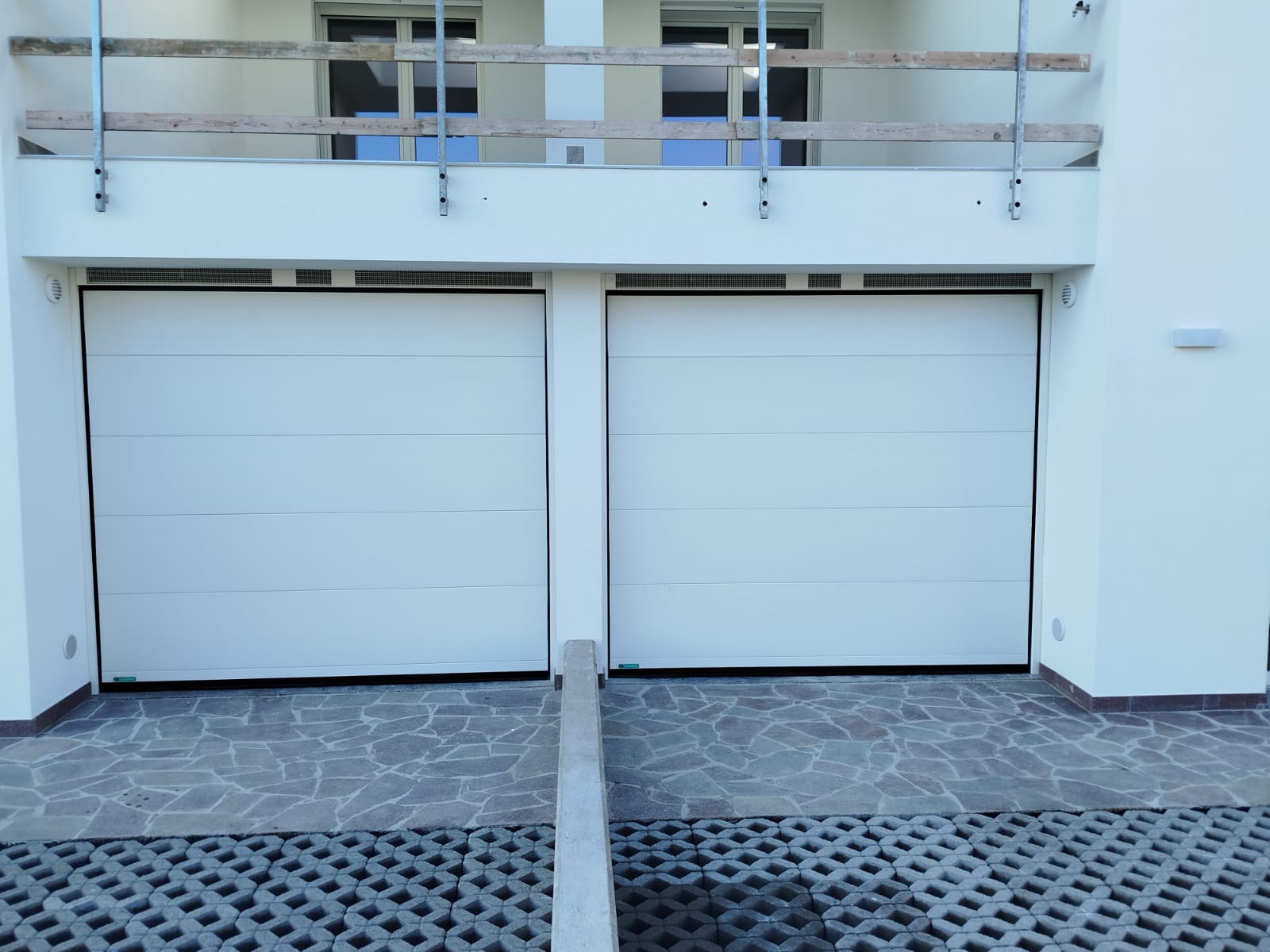 porta sezionale a <p>porta sezionale oltre luce, con veletta areata e pannello intero. RAL 9010</p>