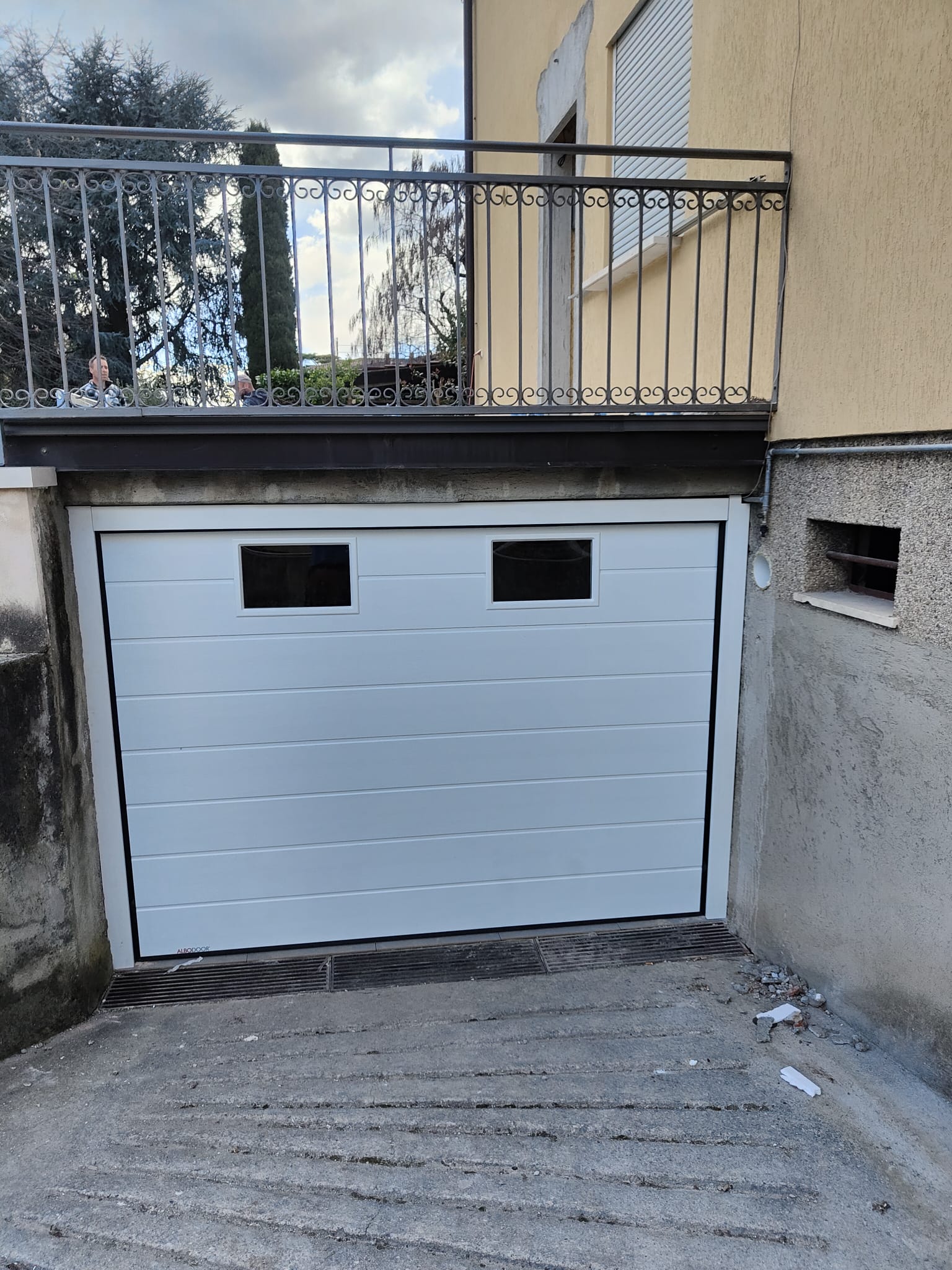 porta sezionale a <p>porta sezionale in luce, con oblò e pannello con doga da 25cm. RAL 9010</p>