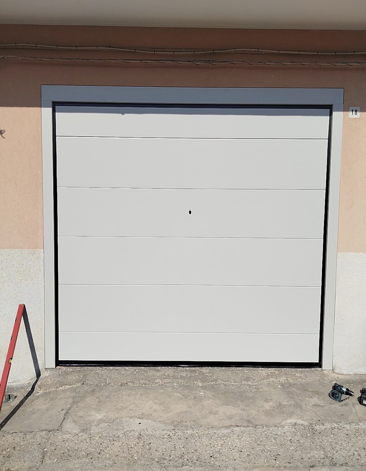 porta sezionale a <p>porta sezionale in luce, con sblocco esterno e pannello intero. RAL 9010</p>