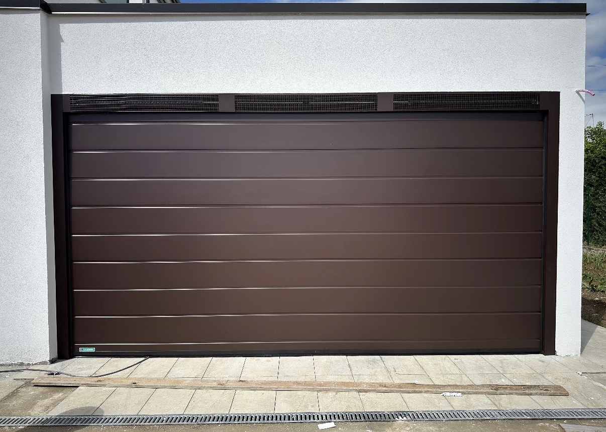 porta sezionale a <p>porta sezionale in luce, con veletta areata e pannello con doga da 25cm. RAL a campione </p>