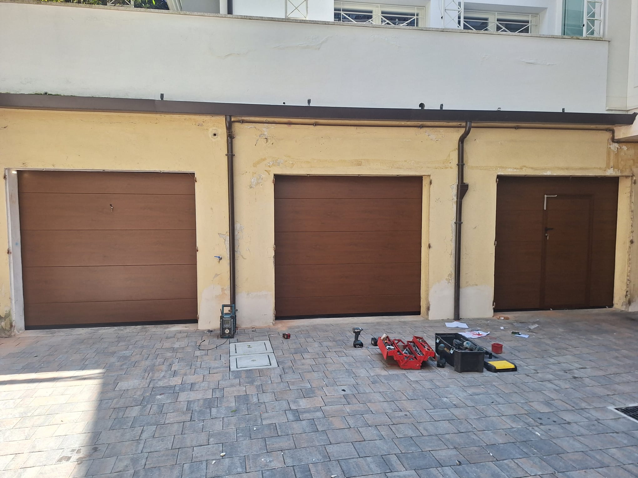 porta sezionale a <p>porta sezionale oltre luce, con sblocco esterno, portina inserita e pannello intero. Colore effetto legno</p>