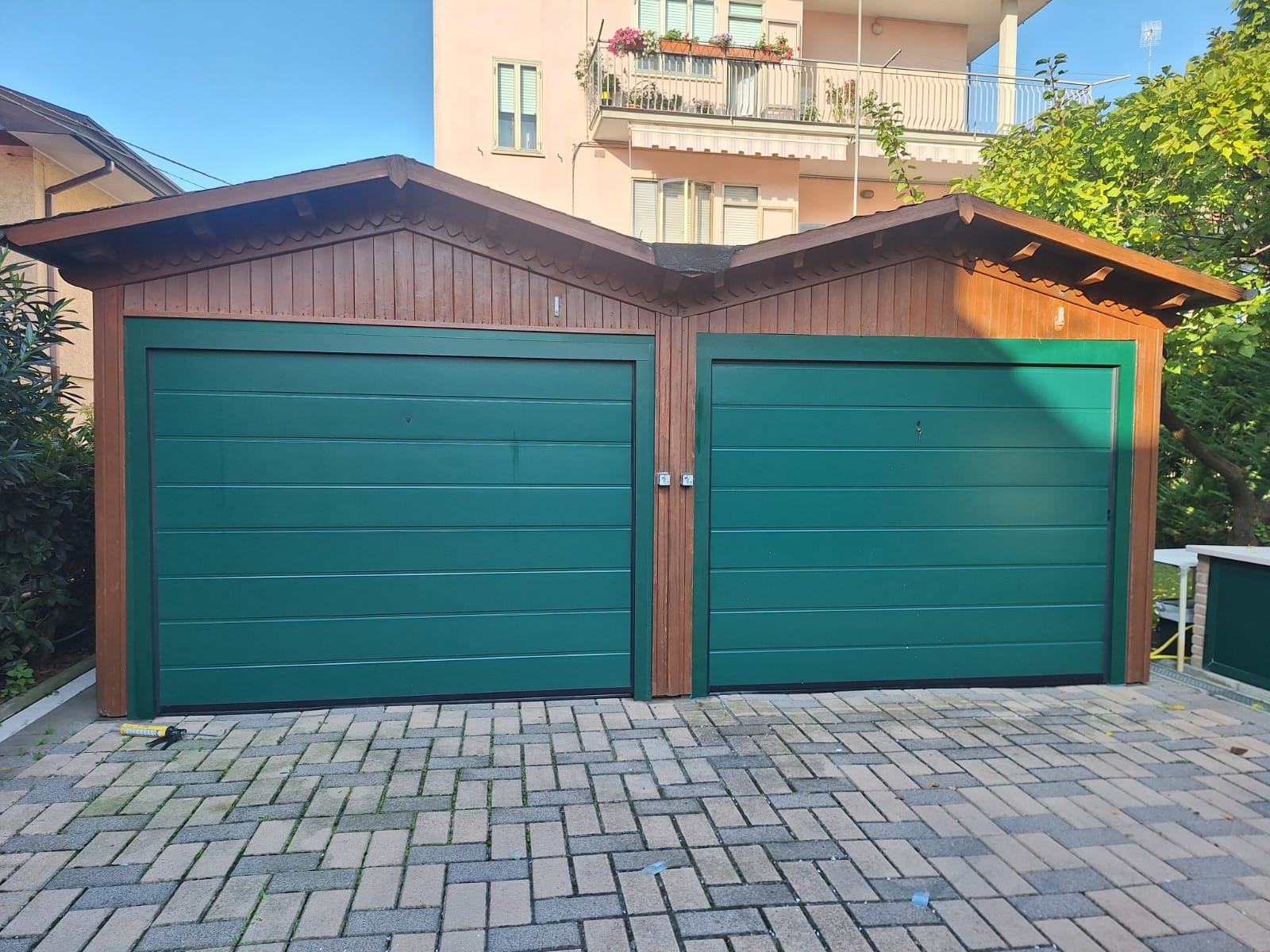 porta sezionale a <p>porta sezionale in luce, con sblocco esterno, coprifili e pannello con doga da 25cm. RAL 6005</p>