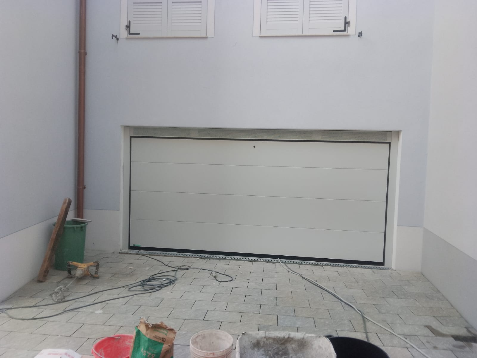porta sezionale a <p>porta sezionale in luce, con veletta areata, sblocco esterno e pannello intero. RAL 9010 </p>