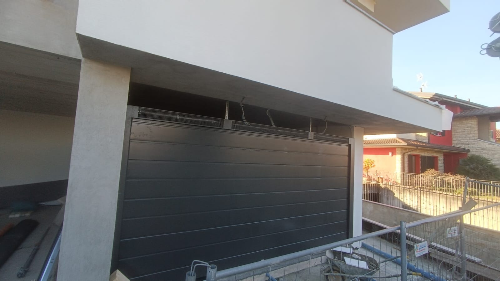 porta sezionale a <p>porta sezionale in luce, con veletta areata e pannello con doga da 25cm. RAL 7016</p>