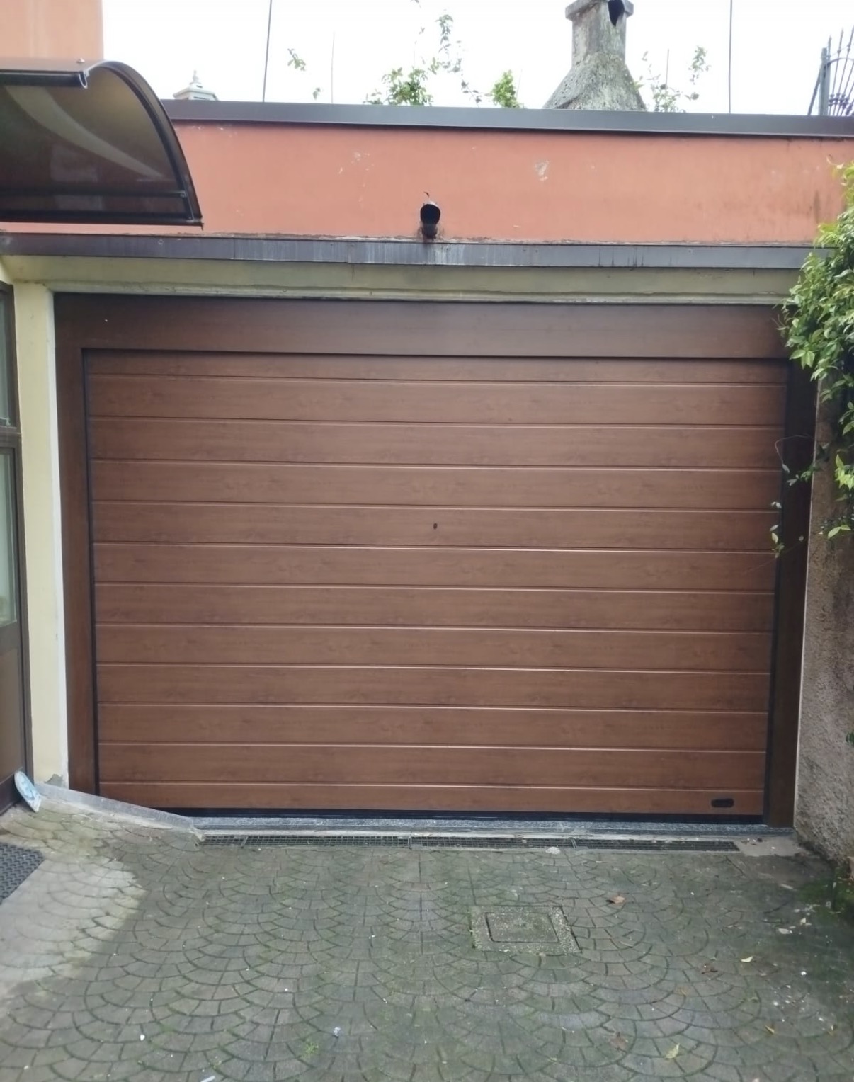 porta sezionale a <p>porta sezionale in luce, con sblocco esterno, maniglia di sollevamento e pannello con doga da 25cm. Colore effetto legno </p>