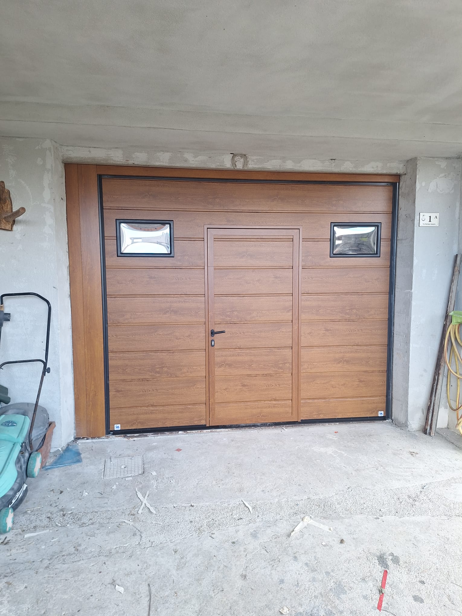 porta sezionale a <p>porta sezionale in luce, con oblò, portina inserita e pannello con doga da 25cm. Colore effetto legno chiaro </p>