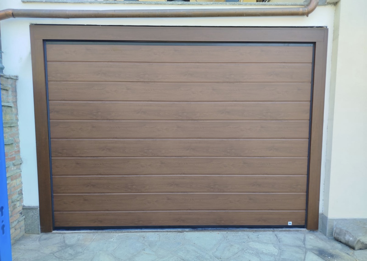 porta sezionale a <p>porta sezionale in luce, con pannello con doga da 25cm. Colore effetto legno</p>
