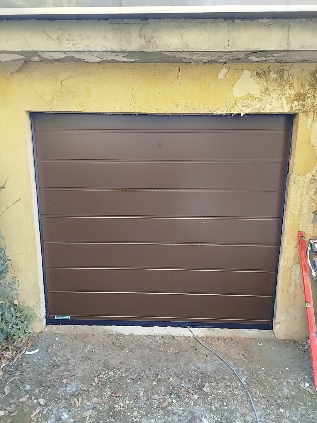 porta sezionale a <p>porta sezionale oltre luce, con sblocco esterno e pannello con doga da 25cm. RAL 8014</p>