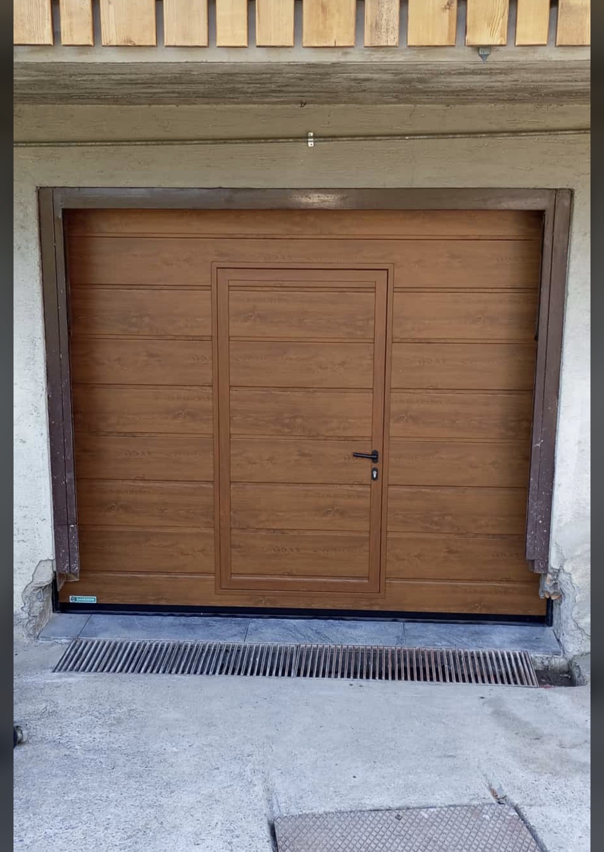 porta sezionale a <p>porta sezionale oltre luce, con portina inserita e pannello con doga da 25cm. Colore effetto legno chiaro</p>