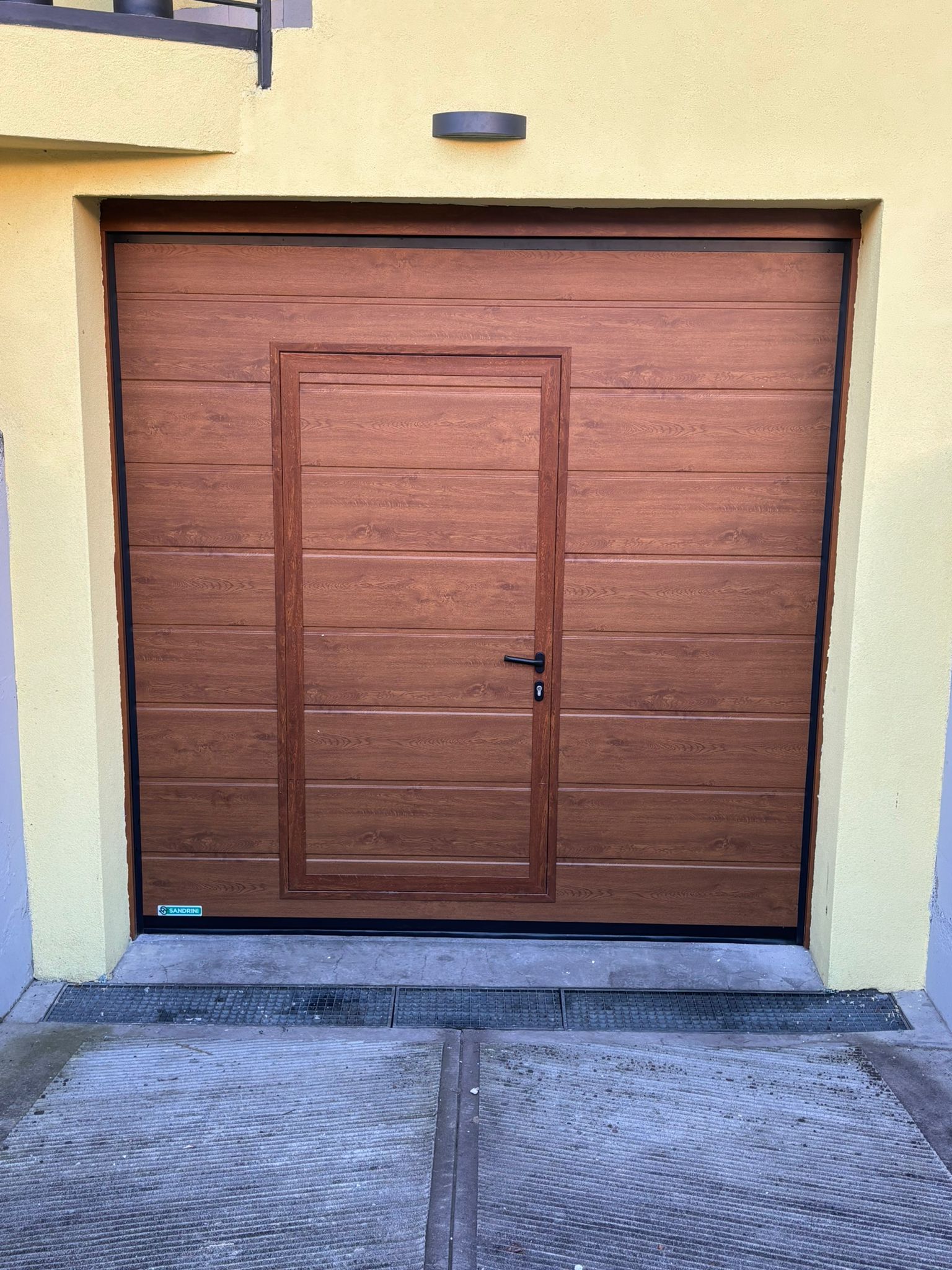 porta sezionale a <p>porta sezionale oltre luce, con portina inserita e pannello con doga da 25cm. Colore effetto legno</p>