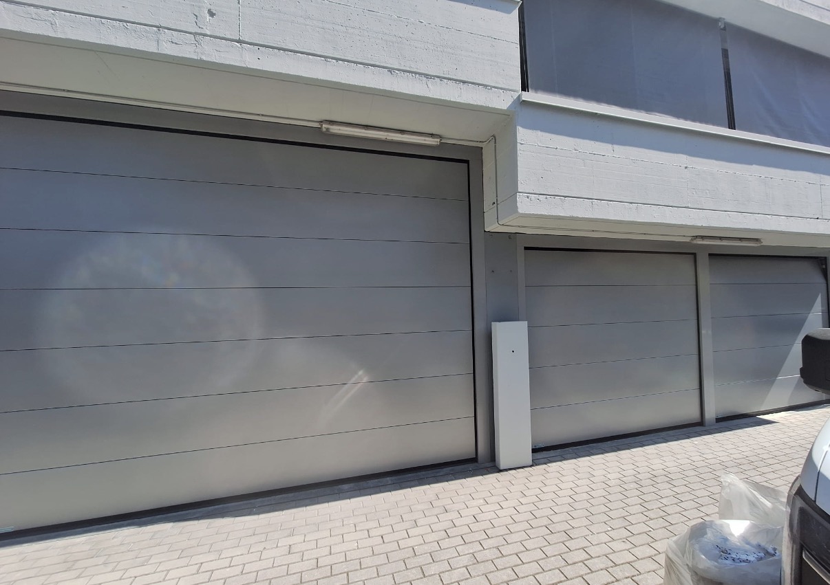 porta sezionale a <p>porta sezionale in luce, con sblocco esterno e pannello intero. RAL 9006</p>