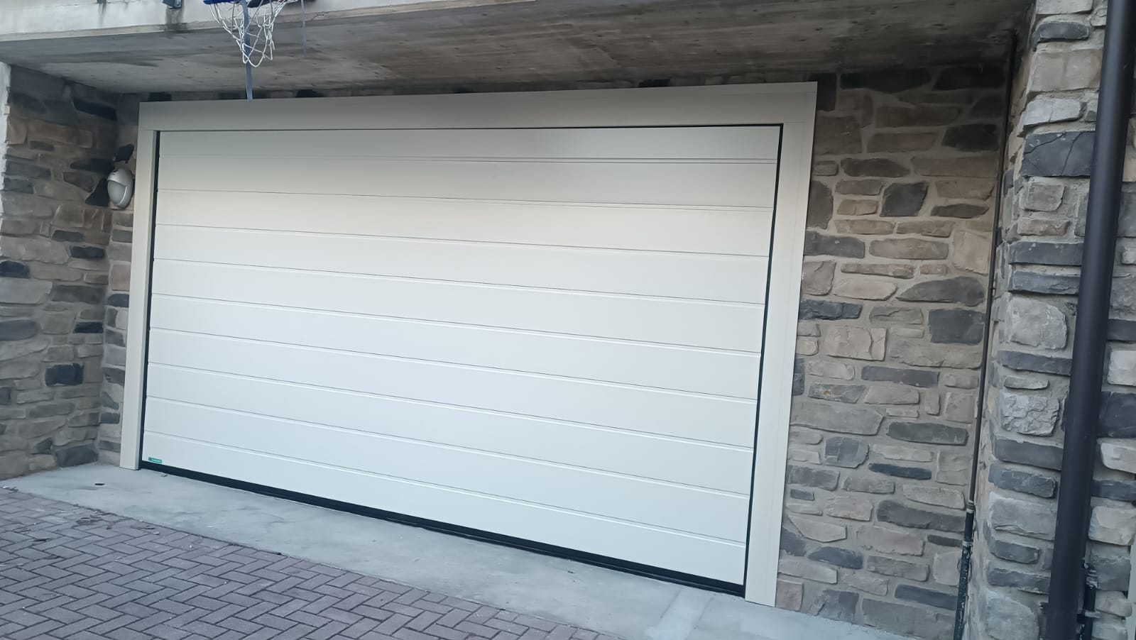 porta sezionale a <p>porta sezionale in luce, con coprifili e pannello con doga da 25cm. RAL 9010</p>