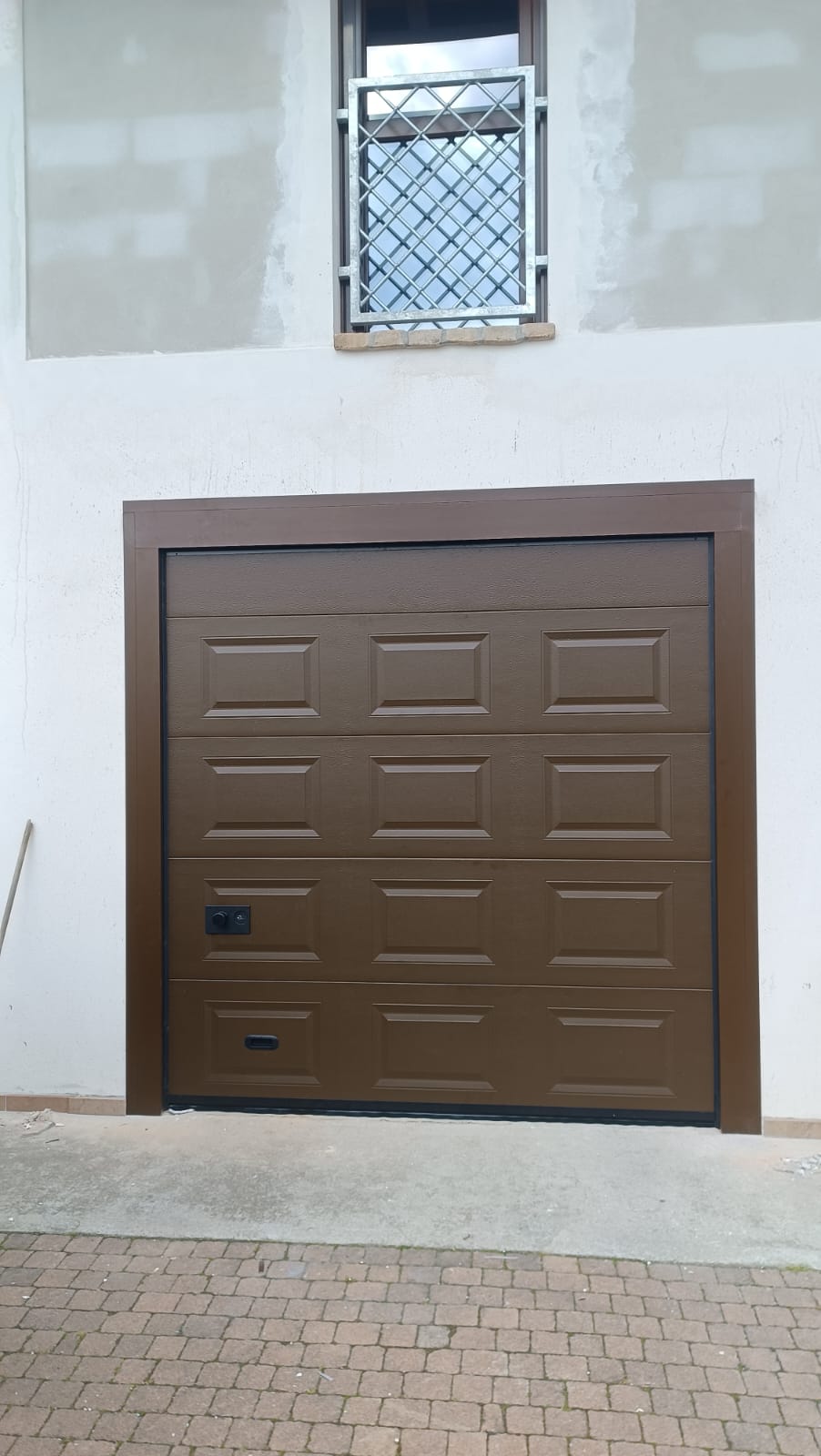 porta sezionale a <p>porta sezionale in luce, con coprifili, maniglia di sollevamento, maniglia di apertura e pannello intero cassettato. RAL 80114 </p>