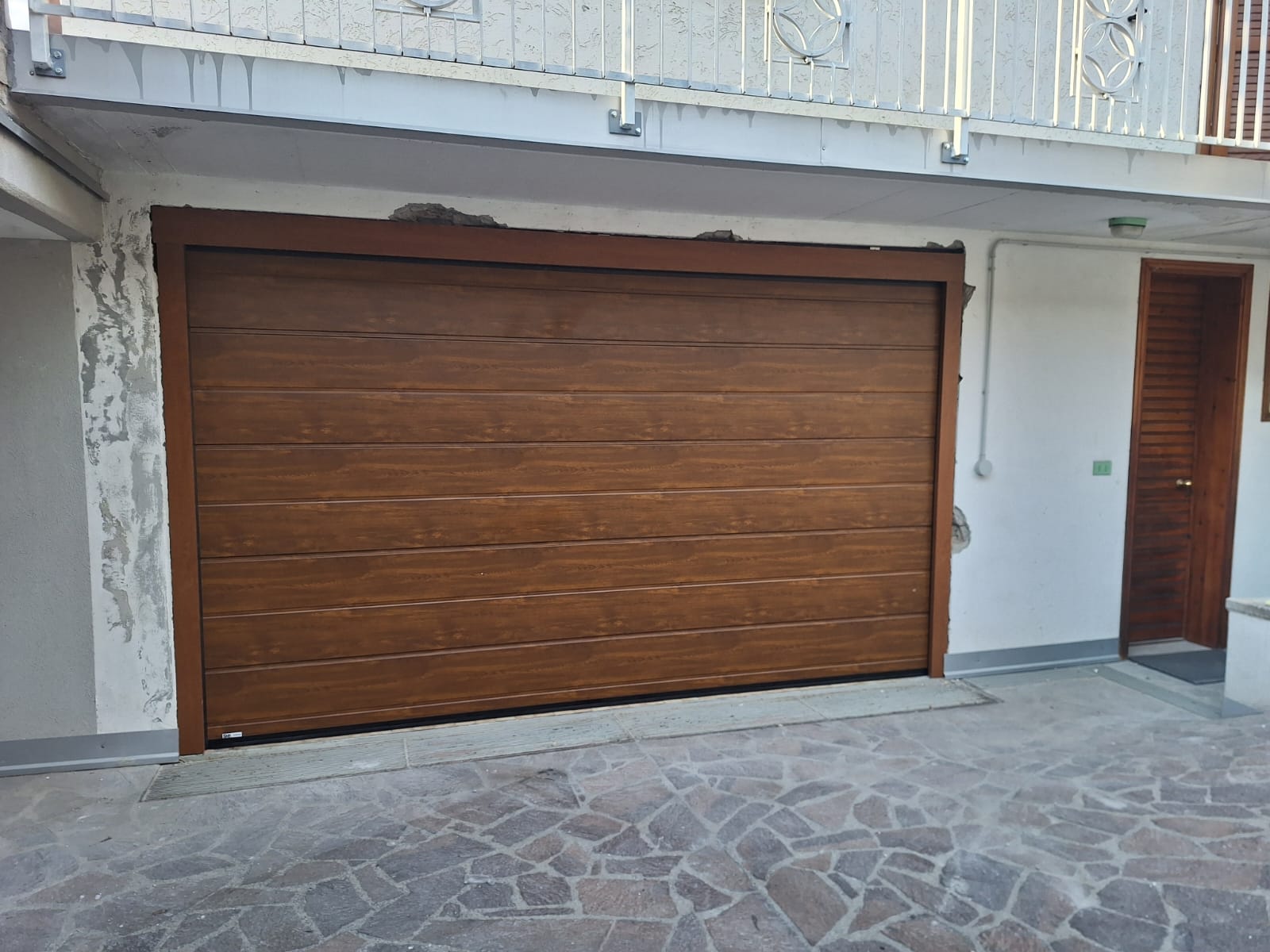 porta sezionale a <p>porta sezionale in luce, con pannello con doga da 25cm. colore effetto legno scuro </p>