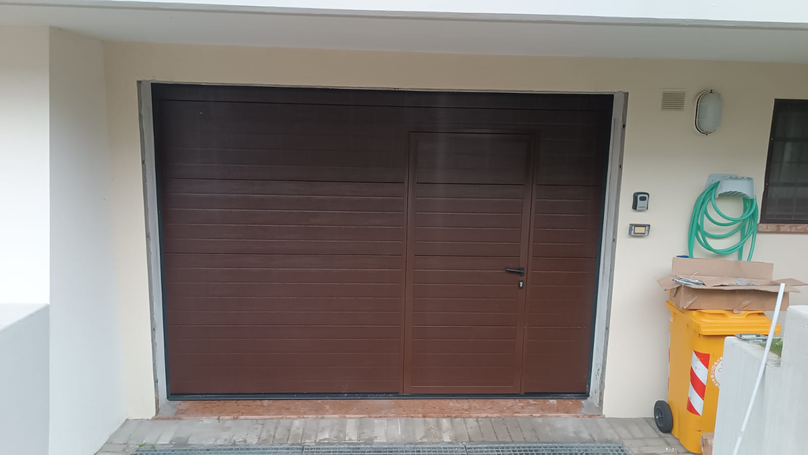 porta sezionale a <p>porta sezionale oltre luce, con portina inserita e pannello con doga da 10cm. RAL 8014</p>