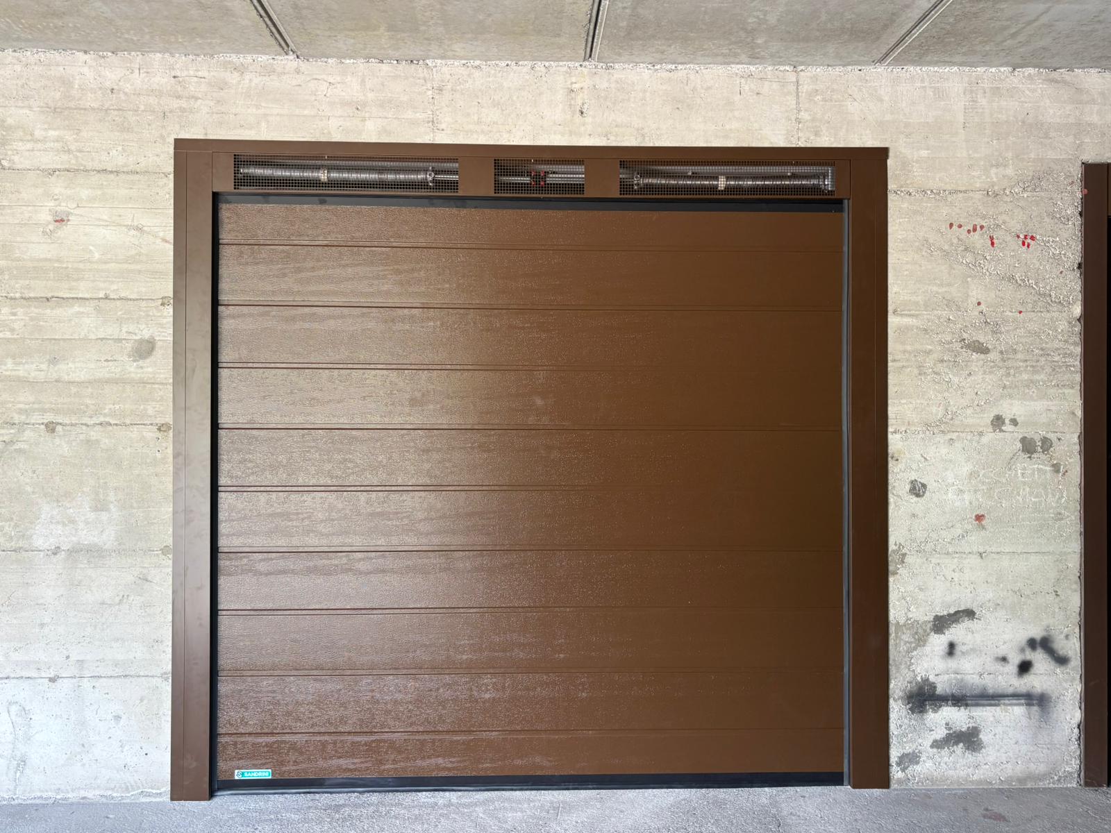 porta sezionale a <p>porta sezionale in luce, con veletta areata, coprifili e pannello con doga da 25cm. RAL 8014 </p>