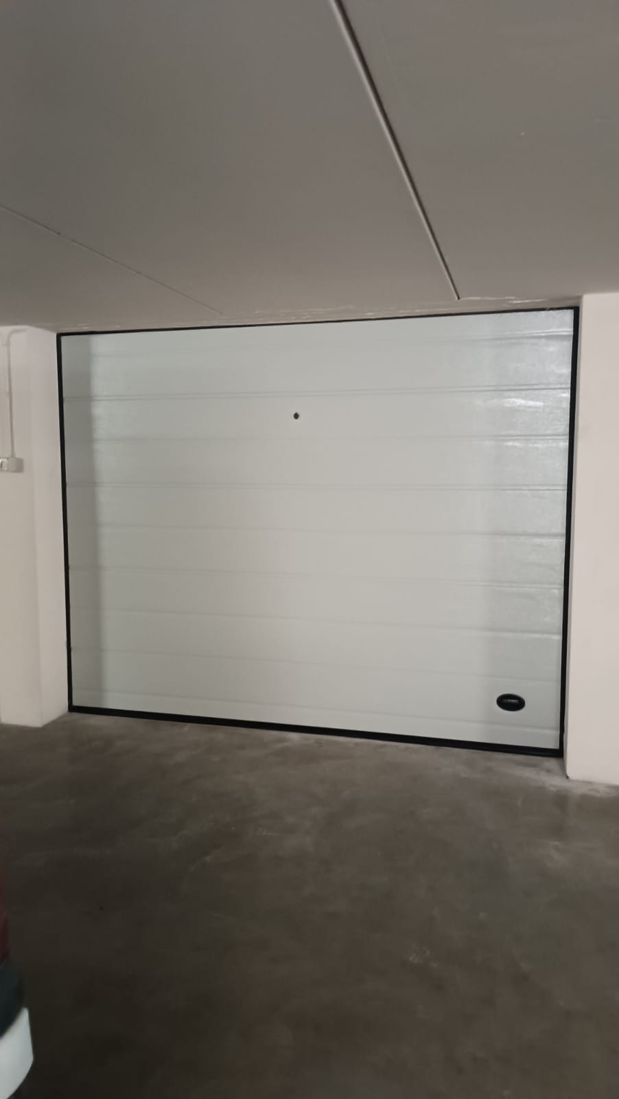 porta sezionale a <p>porta sezionale oltre luce, con sblocco esterno, maniglia di sollevamento e pannello con doga da 25cm. RAL 9010</p>