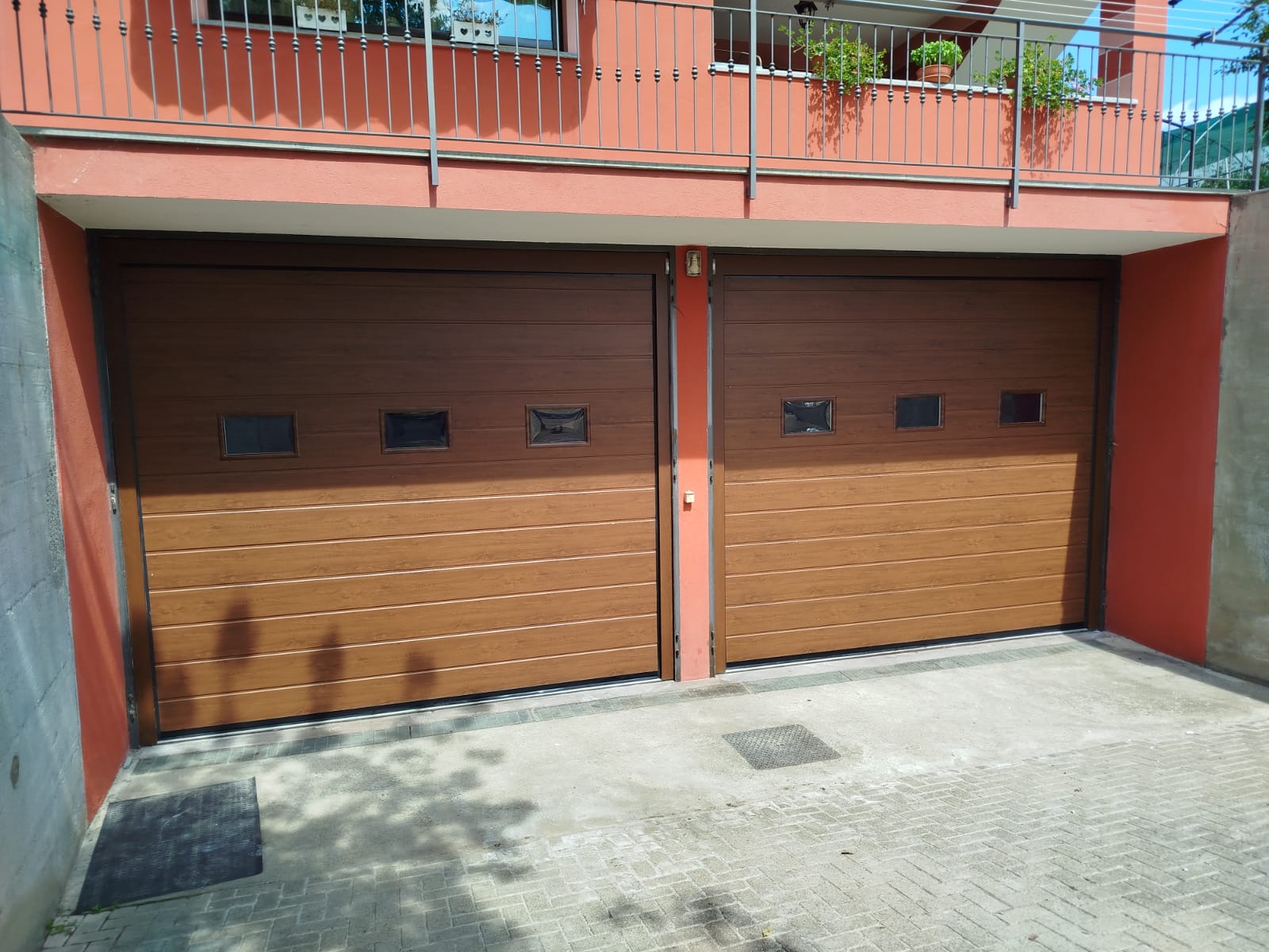 Porta sezionale a <p>Porta sezionale in luce, con oblò, lampeggiante e pannello con doga da 25cm. Colore effetto legno </p>