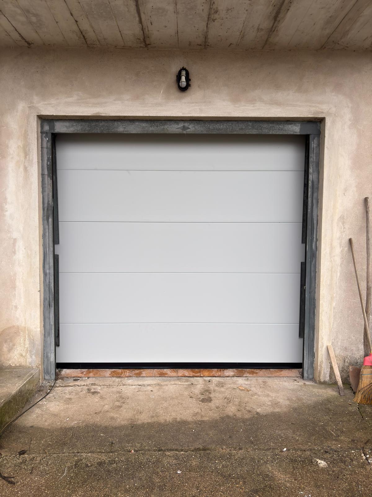 porta sezionale a <p>porta sezionale oltre luce, con pannello intero. RAL 7035</p>