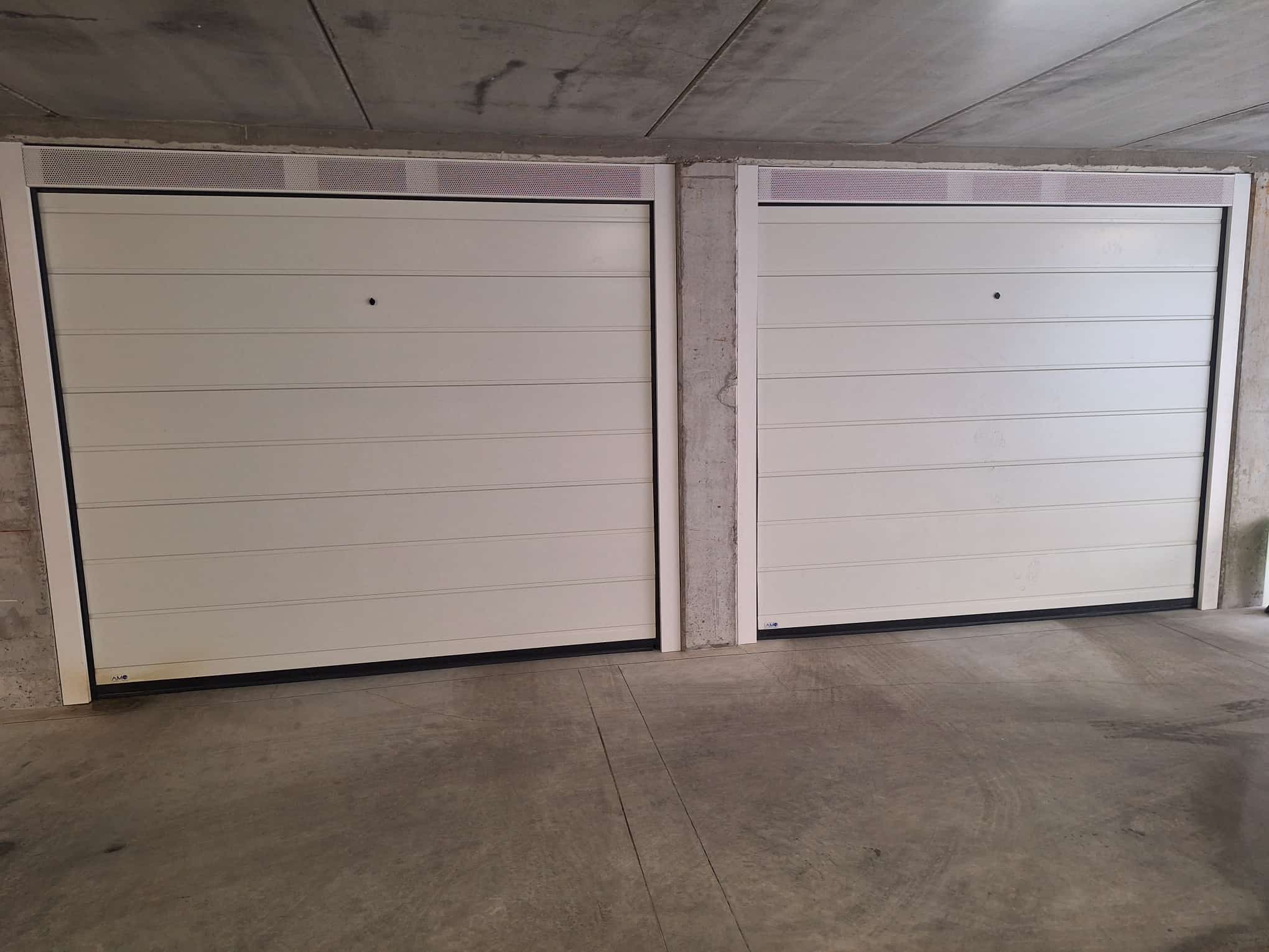 porta sezionale a <p>porta sezionale in luce, con veletta areata, sblocco esterno e pannello con doga da 25cm. RAL 9010</p>