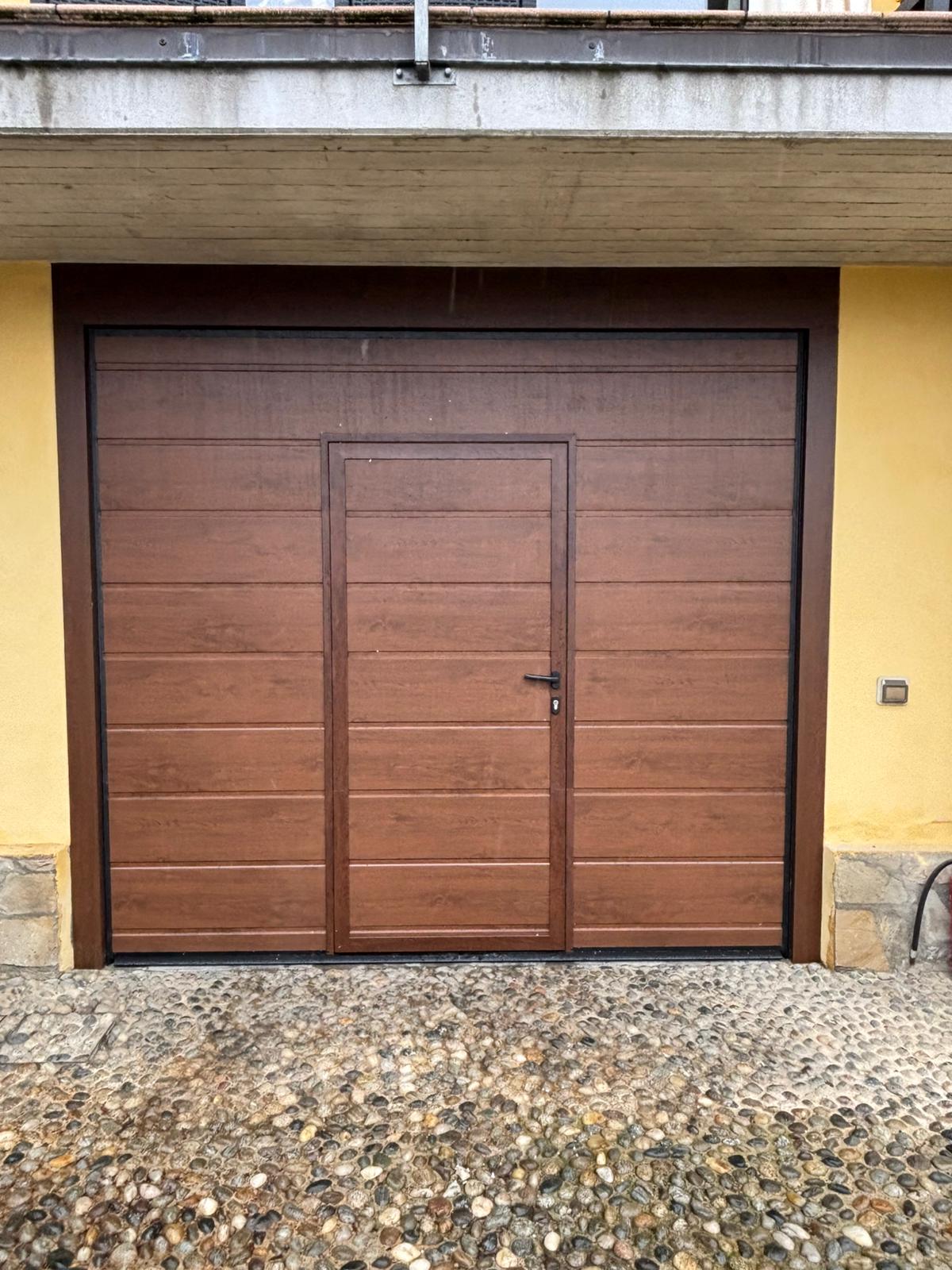 porta sezionale a <p>porta sezionale in luce, con portina inserita e pannello con doga da 25cm. Colore effetto legno</p>