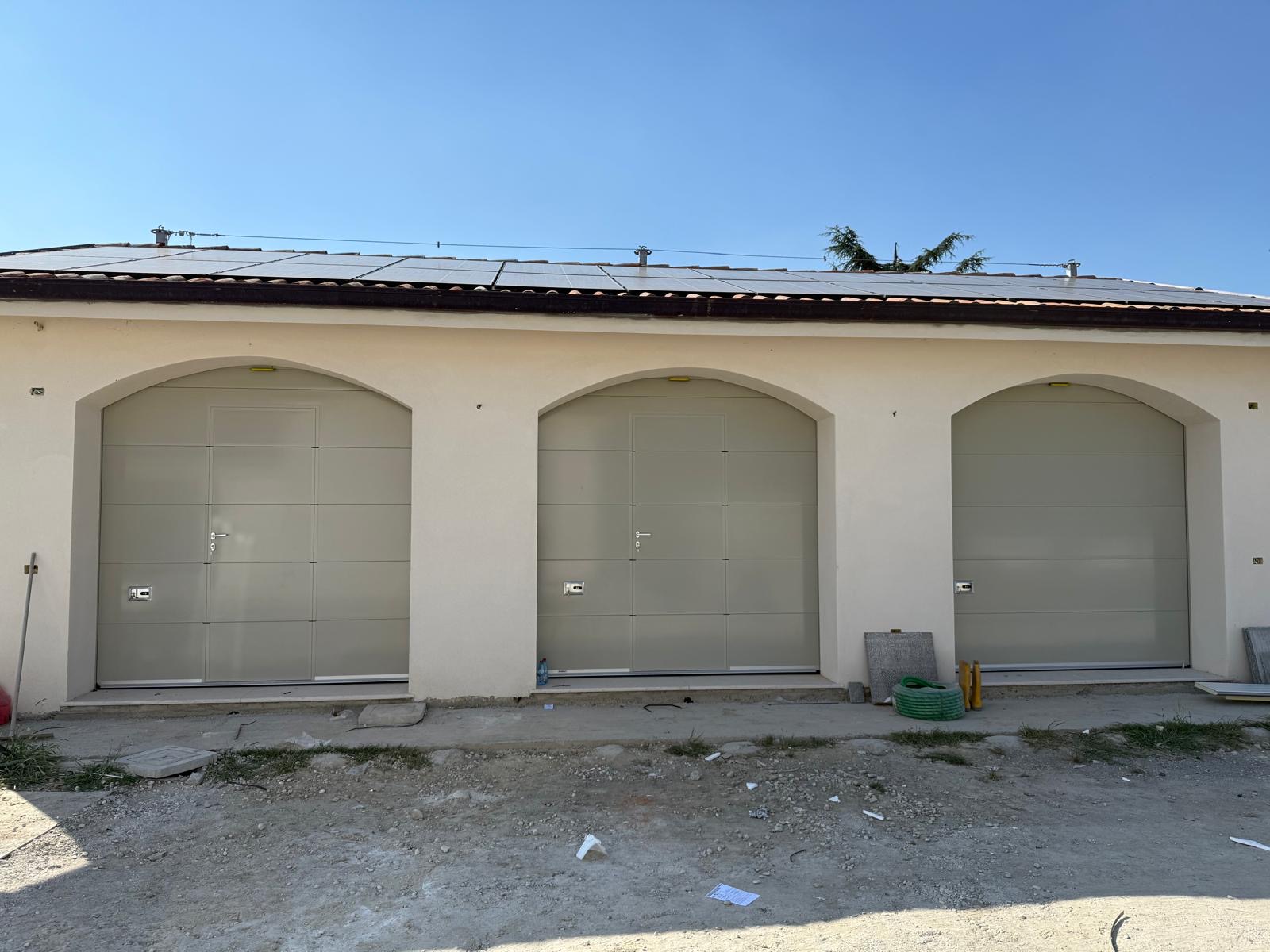 Porta sezionale a <p>Porta sezionale manuale oltre luce, con portina inserita e pannello intero. RAL a campione </p>