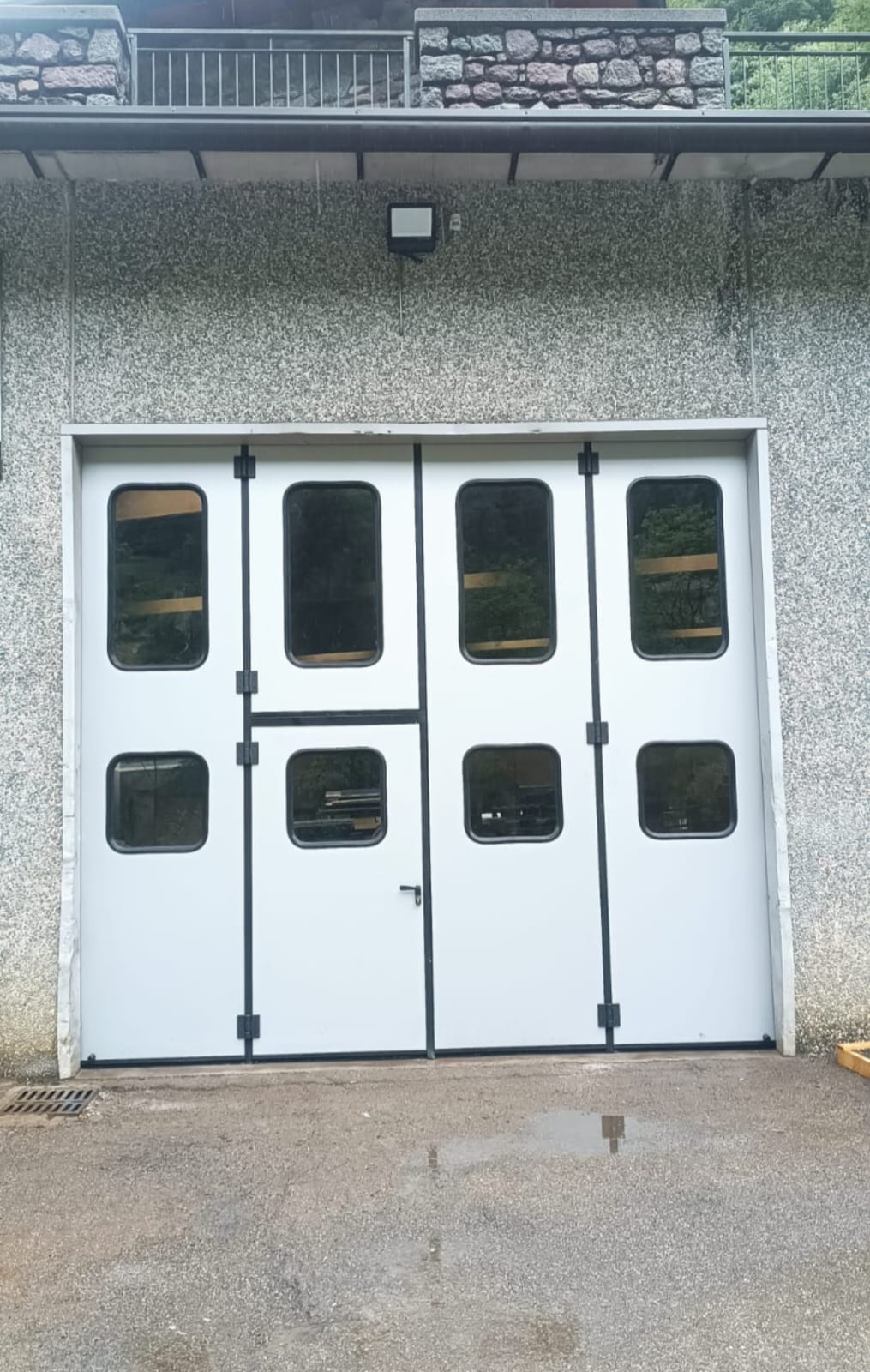 portone a libro a <p>portone a libro, con portina inserita e oblò, apertura 2+2. RAL 9010</p>