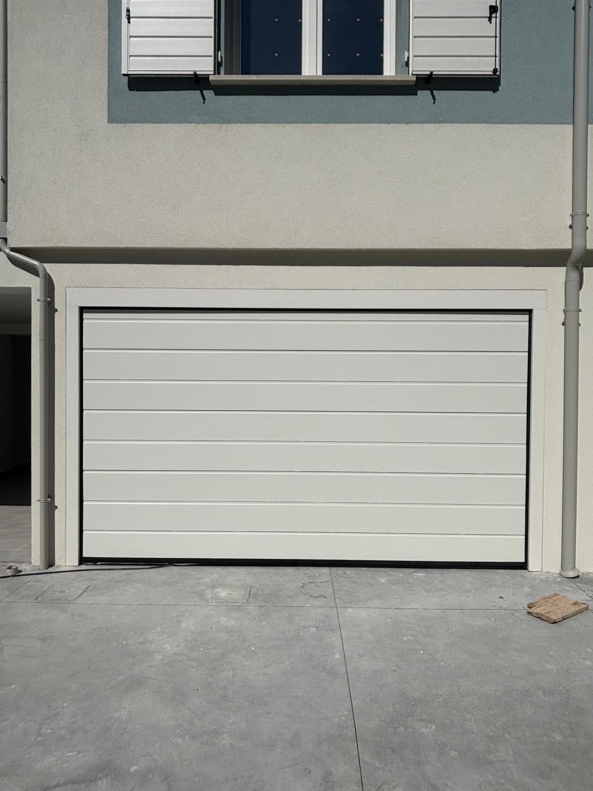 porta sezionale a <p>porta sezionale in luce, con pannello con doga da 25cm. RAL 9010</p>