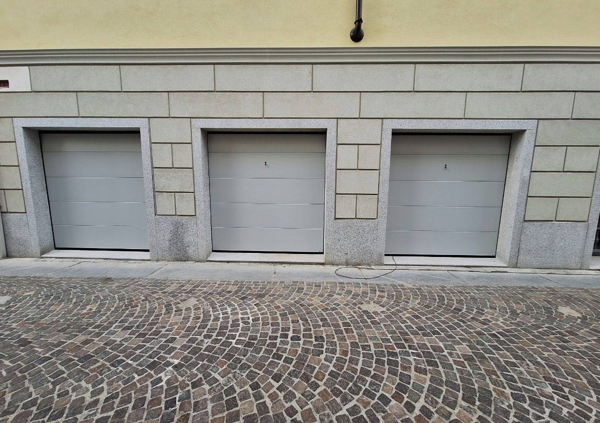 porta sezionale a <p>porta sezionale oltre luce, con sblocco esterno e pannello intero. RAL 7035</p>
