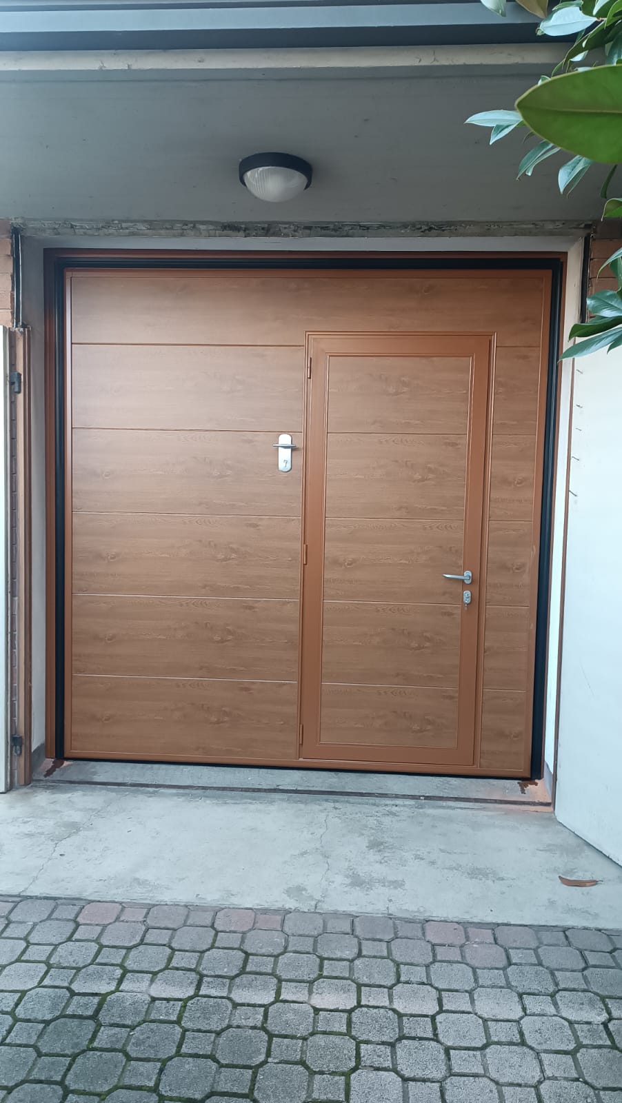 porta basculante coibentata a <p>porta basculante coibentata, con maniglia esterna, portina inserita e pannello intero. Colore effetto legno</p>