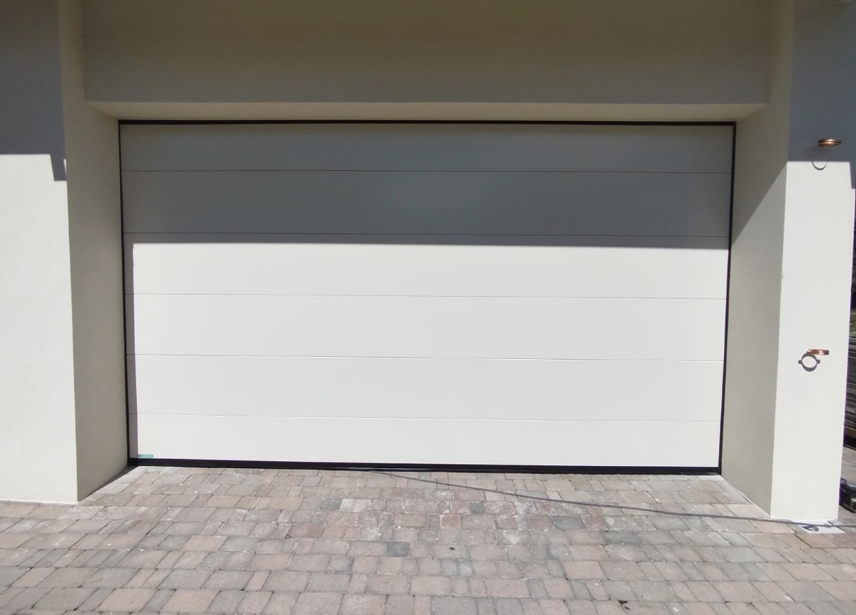 porta sezionale a <p>porta sezionale oltre luce, con pannello intero. RAL 1013</p>
