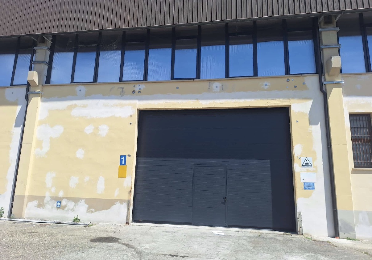 porta sezionale industriale a <p>porta sezionale industriale oltre luce, con portina inserita e pannello con doga da 10cm. RAL 7016</p>